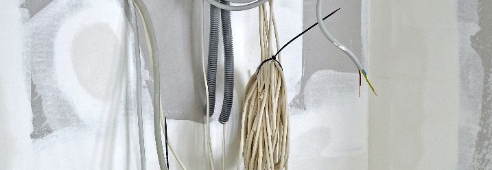 Kabel hängen aus unverputzter Wand